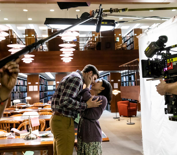 Two actors on film set in a library